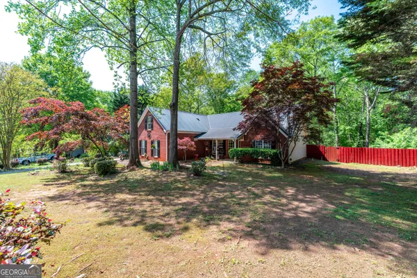 a view of a yard in front of a house with large tree