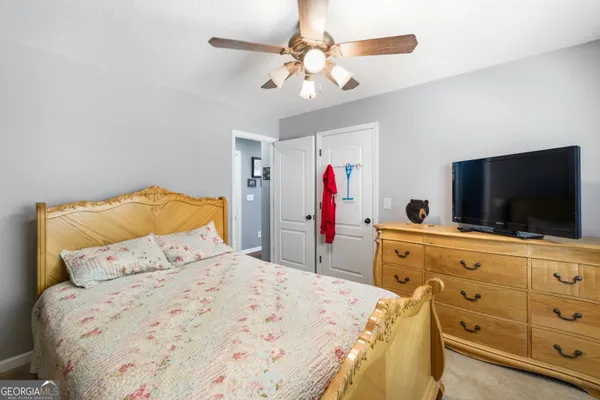 a bedroom with a bed and a flat tv screen on dresser
