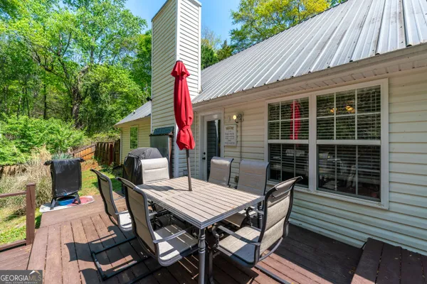a view of a patio with table and chairs with wooden floor and fence