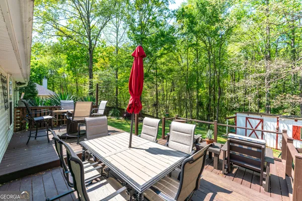 a view of a patio with a dining table and chairs with wooden floor and fence
