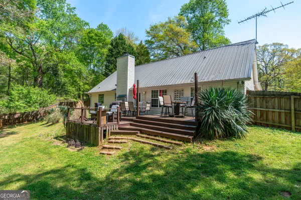 a view of a house with backyard and sitting area