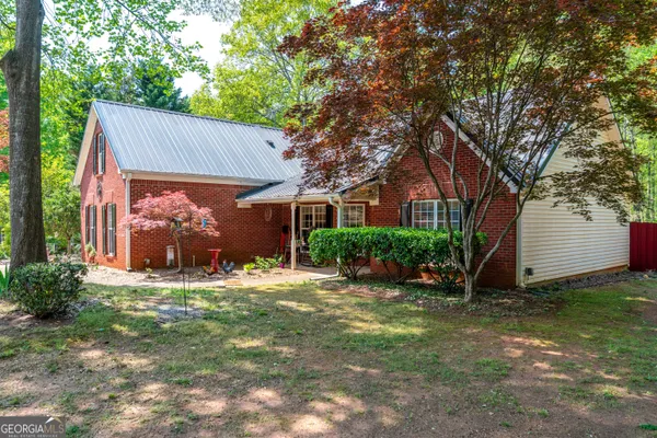 a view of a house with a yard and tree