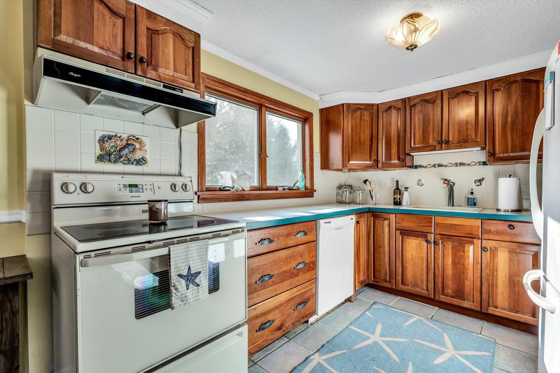 19 Pine Rock Road East Falmouth, MA 02536 - Photo 16 of 52 a kitchen with stainless steel appliances granite countertop a stove a sink and a microwave