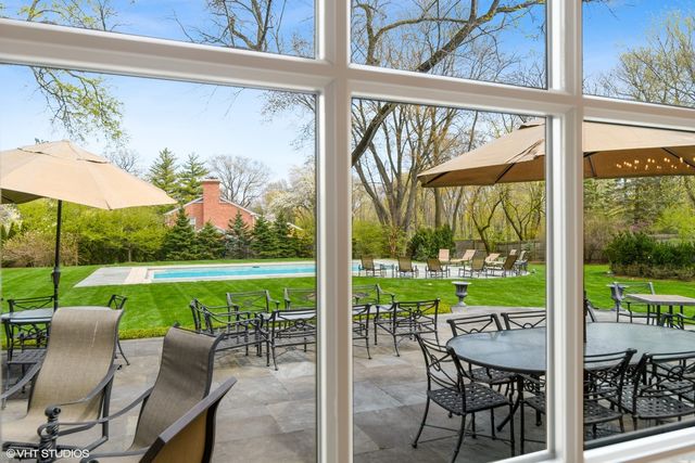 a spacious bedroom with a bed a fireplace and a chandelier