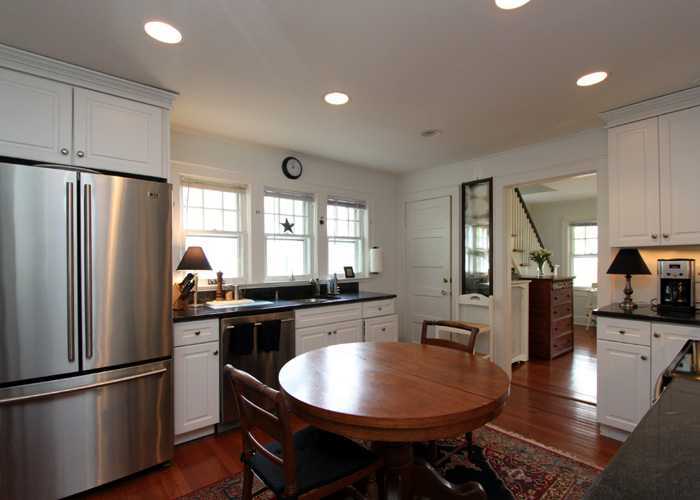 83 Strickland Road, Unit A Cos Cob, CT 06807 - Photo 5 of 8 a kitchen with stainless steel appliances granite countertop a refrigerator a stove a sink a dining table and chairs