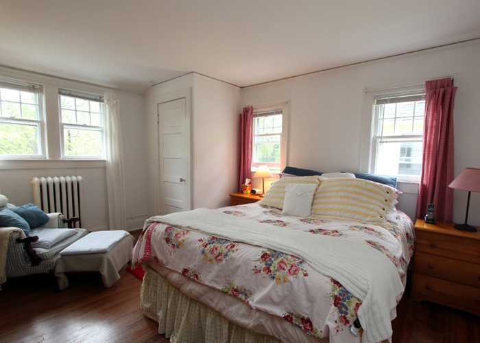 83 Strickland Road, Unit A Cos Cob, CT 06807 - Photo 6 of 8 a bedroom with a bed a couch and windows