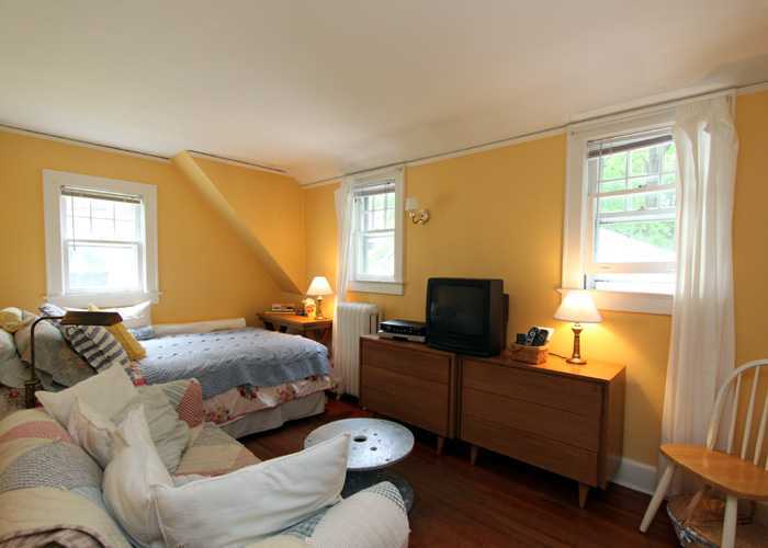 83 Strickland Road, Unit A Cos Cob, CT 06807 - Photo 7 of 8 a bedroom with a bed and wooden floor