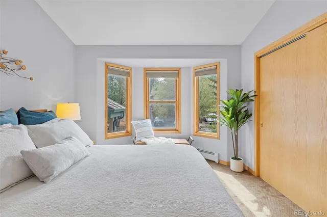 a bedroom with a bed and a couch next to a window