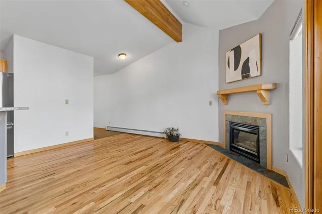 a view of empty room with wooden floor and fireplace