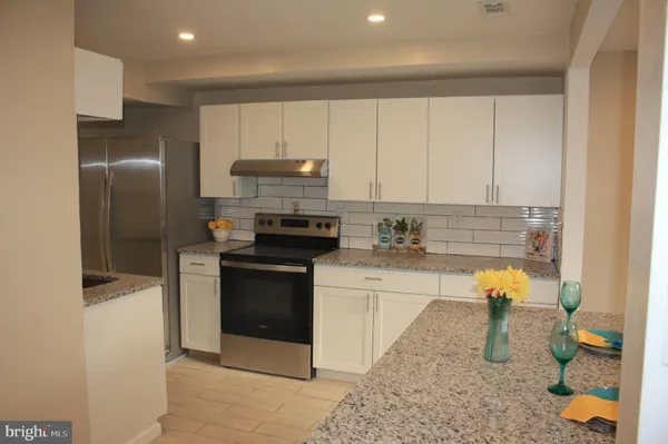 a kitchen with stainless steel appliances a stove a sink and a refrigerator