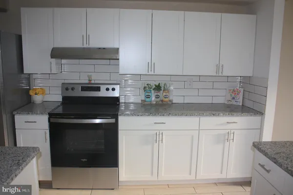 a kitchen with white cabinets and appliances