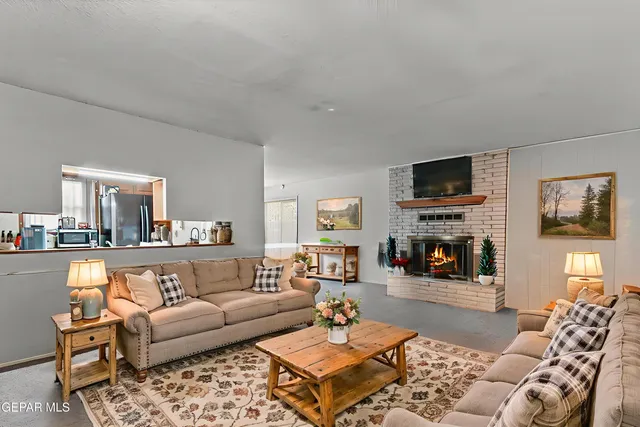 a living room with furniture a fireplace and a flat screen tv