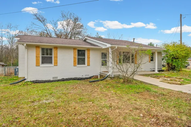 a view of a house with backyard and sitting area