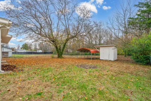 a backyard of a house with table and chairs