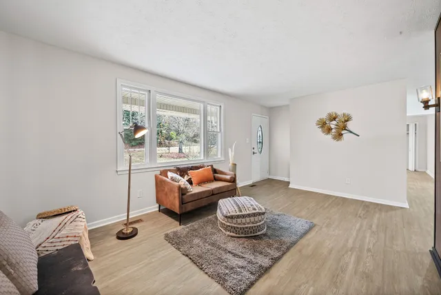 a kitchen with stainless steel appliances granite countertop a refrigerator a stove top oven a sink dishwasher and white cabinets with wooden floor