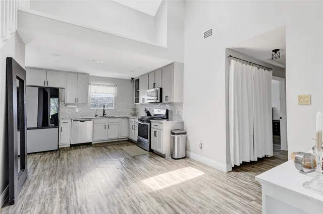 a kitchen with a sink cabinets stainless steel appliances and window