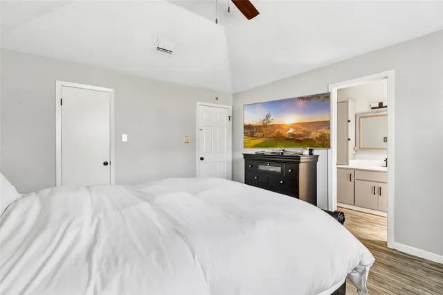 a large white bed in a white room with kitchen