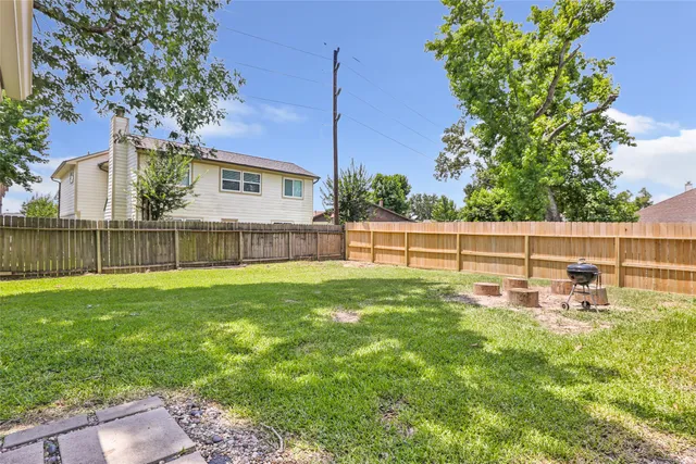 a view of a house with a backyard and a tree