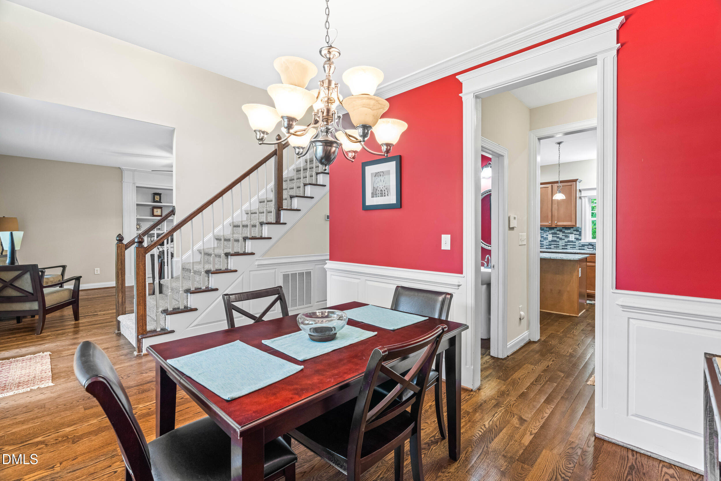 126 Geranium Way Clayton, NC 27527 - Photo 16 of 35 a dining room with wooden floor a chandelier a wooden table and chairs