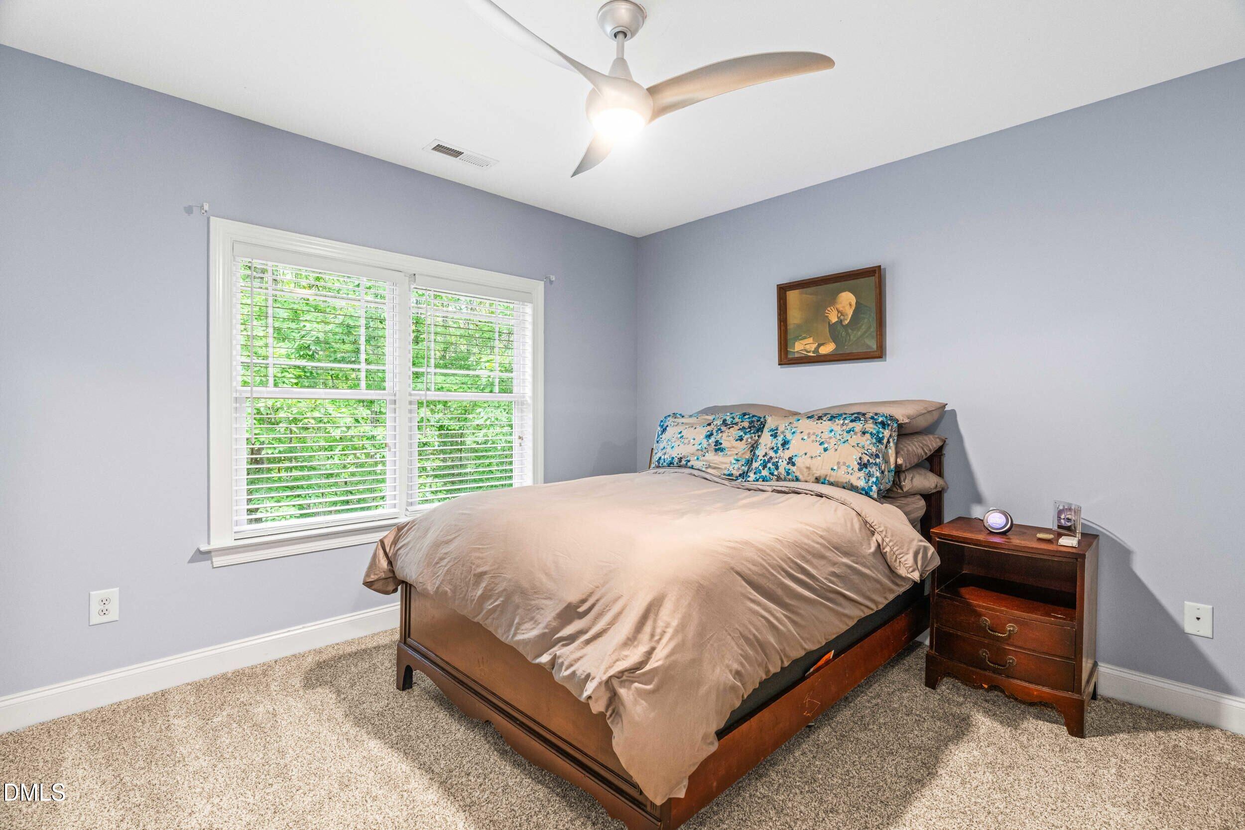 126 Geranium Way Clayton, NC 27527 - Photo 24 of 35 a large bed sitting in a bedroom next to a window and a chandelier
