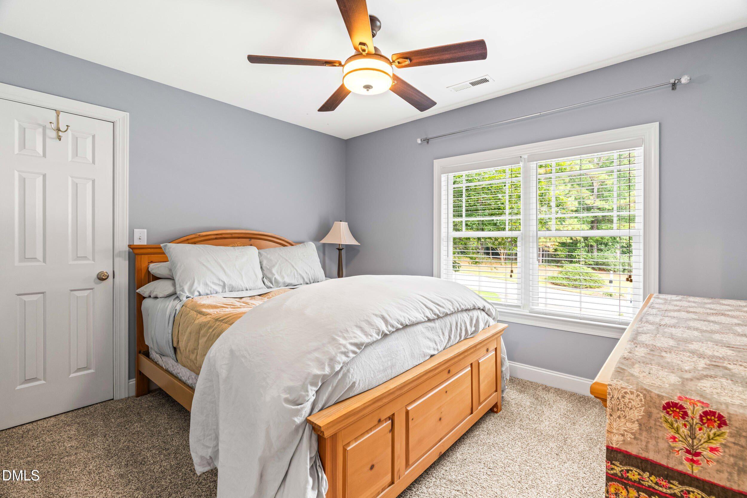 126 Geranium Way Clayton, NC 27527 - Photo 26 of 35 a bed room with a bed and a chandelier