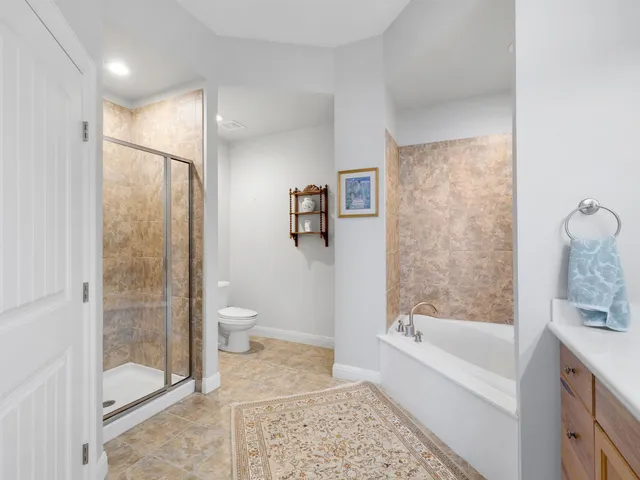 a bathroom with a bathtub shower and toilet
