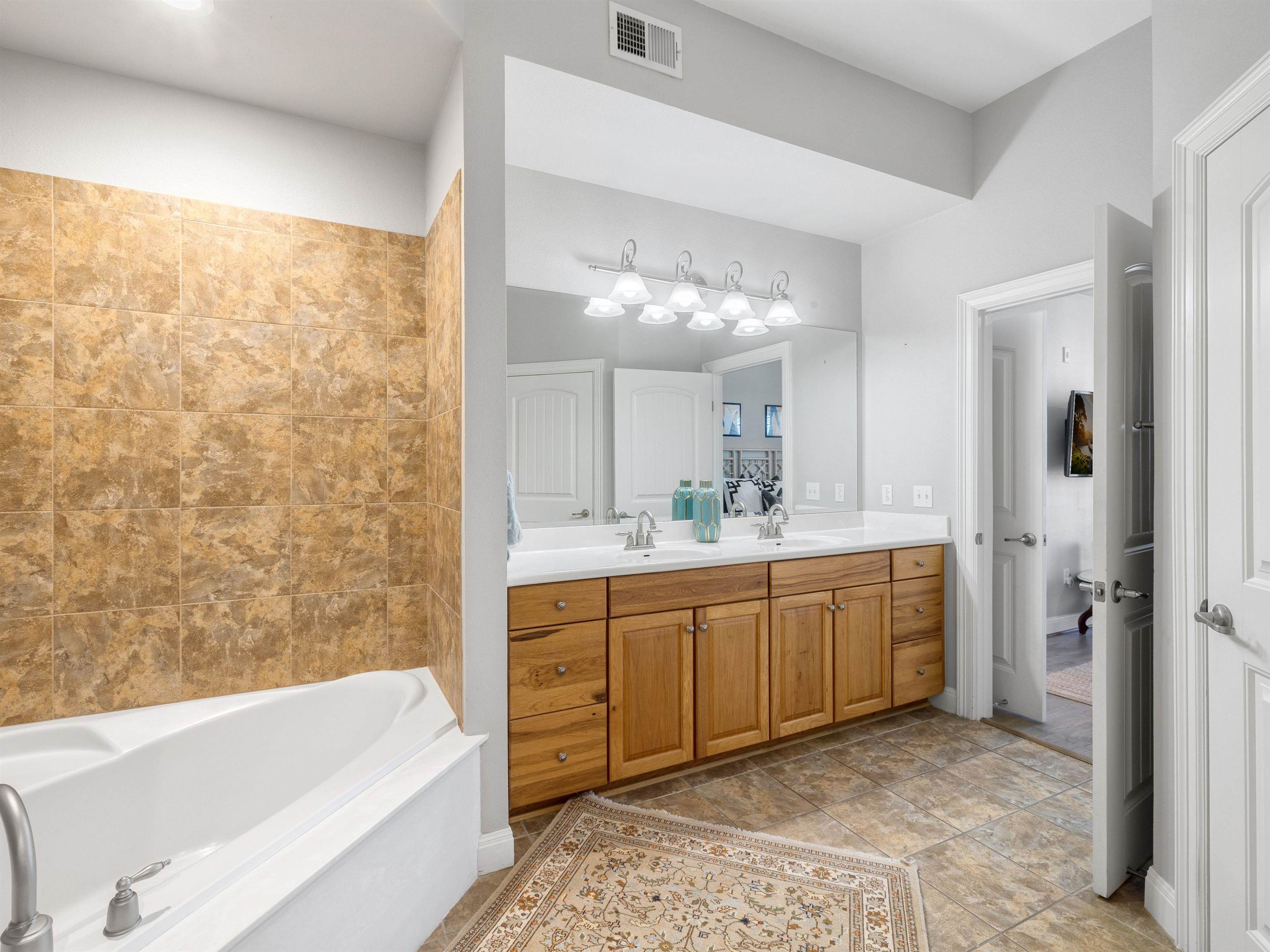 101 West Bank, Unit 44 Horseshoe Bay, TX 78657 - Photo 19 of 22 a bathroom with a tub sink and mirror
