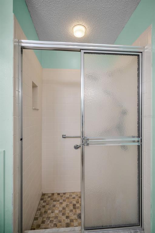 6525 Pine Walk Drive New Port Richey, FL 34655 - Photo 23 of 62 a bathroom with a glass shower door