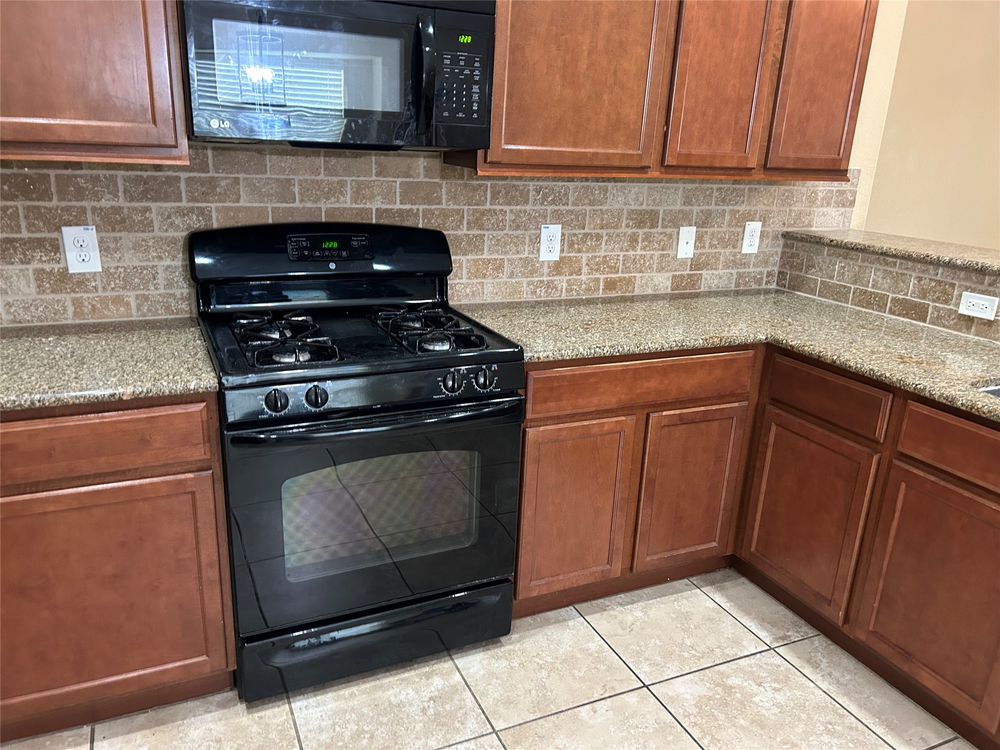 25111 Country Gate Drive Tomball, TX 77375 - Photo 20 of 22 a kitchen with granite countertop cabinets and stove top oven