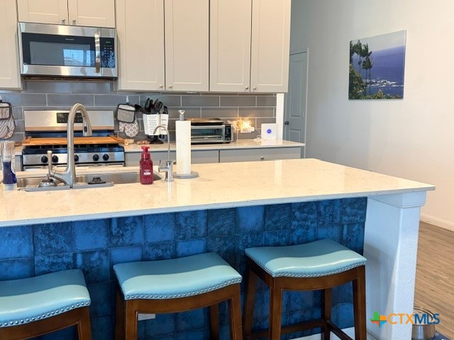 8942 Rancher Place Seguin, TX 78155 - Photo 17 of 48 a room with stainless steel appliances kitchen island granite countertop a table chairs and a wooden cabinet
