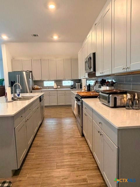 8942 Rancher Place Seguin, TX 78155 - Photo 19 of 48 a kitchen with kitchen island granite countertop a sink a counter top space stainless steel appliances and cabinets