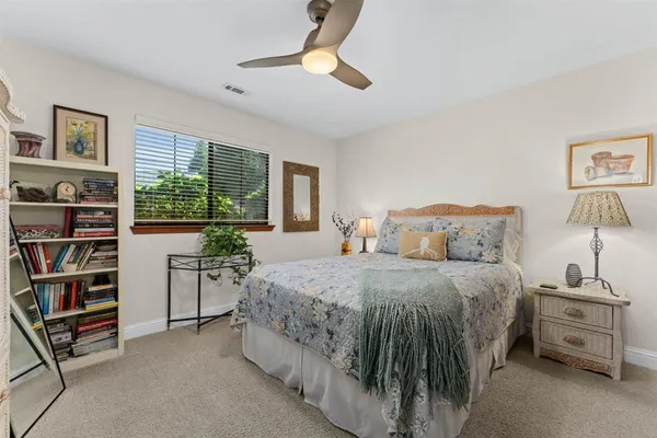a spacious bedroom with a bed and a chandelier