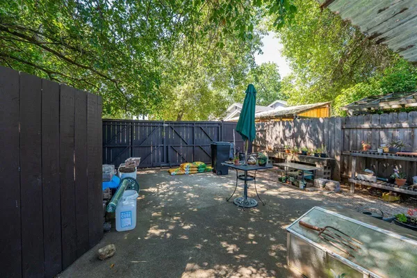 a backyard of a house with barbeque oven and outdoor seating