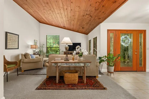 a living room with furniture a large window and potted plants