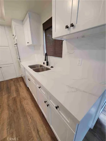 a kitchen with granite countertop white cabinets and white appliances