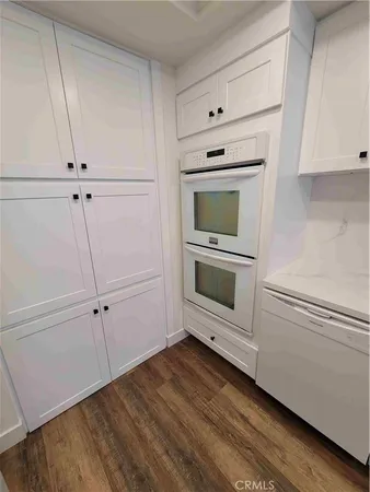a kitchen with white cabinets and white appliances