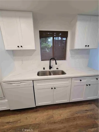 a kitchen with white cabinets and sink