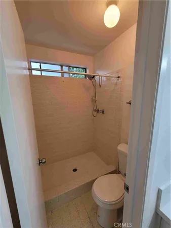 a bathroom with a granite countertop toilet a sink and a shower