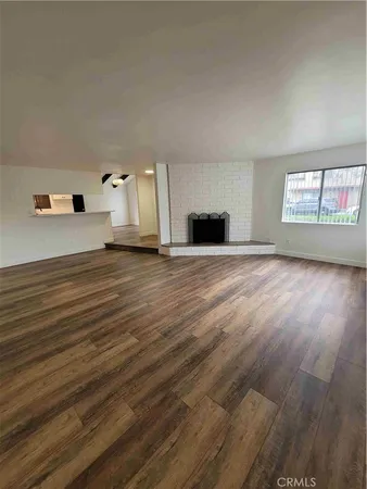 a view of a livingroom with wooden floor and window