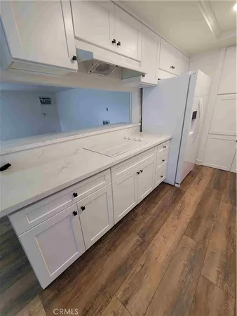 a kitchen with cabinets and wooden floor