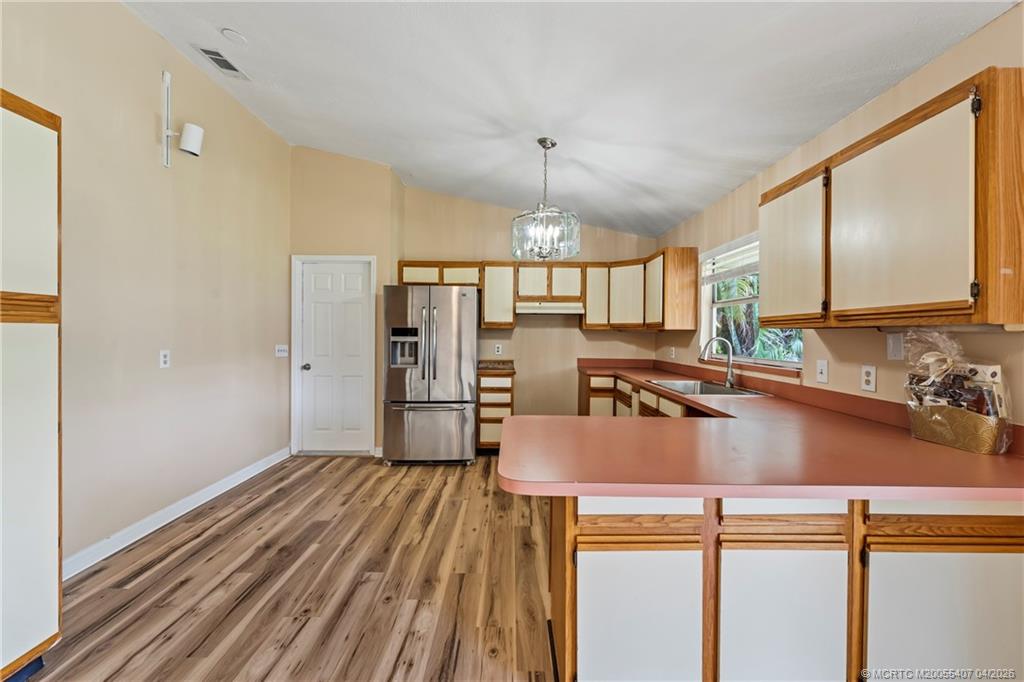 6285 Southeast Highland Avenue Stuart, FL 34997 - Photo 11 of 24 a kitchen with a refrigerator a sink and cabinets