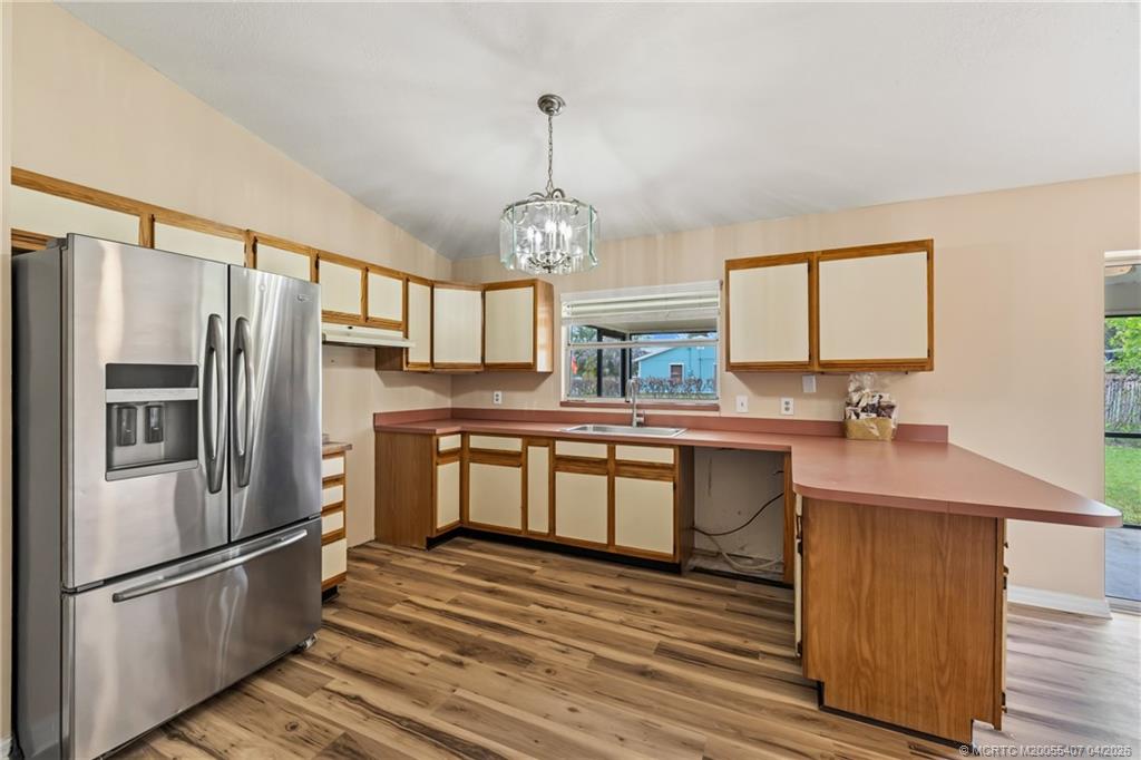 6285 Southeast Highland Avenue Stuart, FL 34997 - Photo 12 of 24 a kitchen with stainless steel appliances a refrigerator sink and cabinets