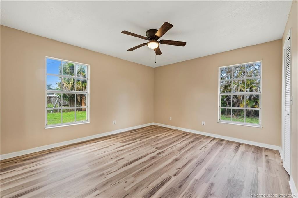 6285 Southeast Highland Avenue Stuart, FL 34997 - Photo 18 of 24 a view of empty room with wooden floor and fan