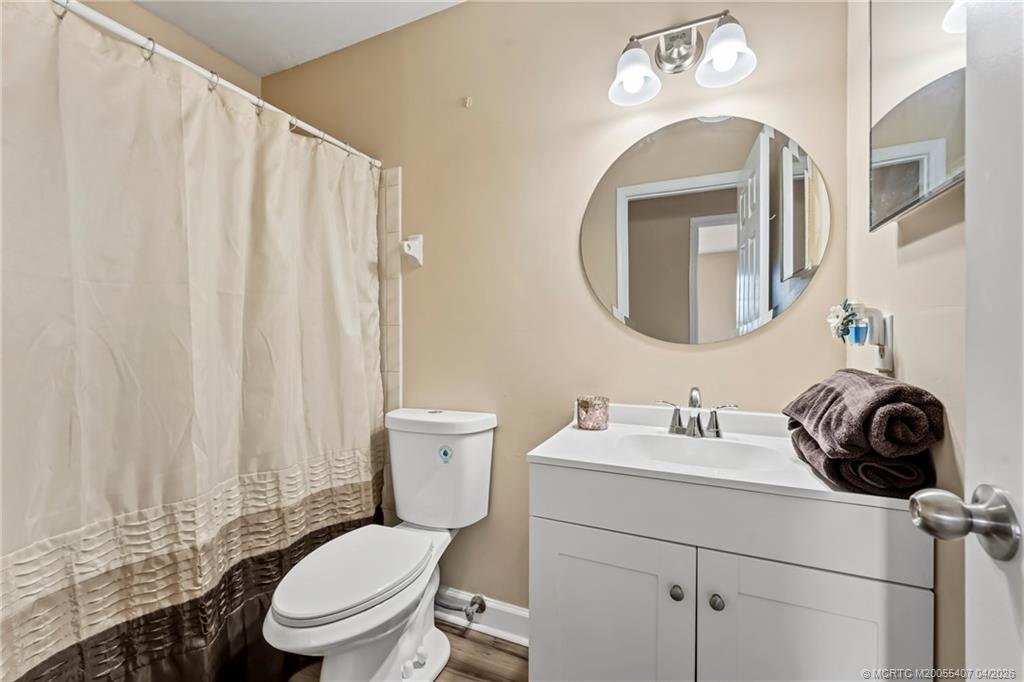 6285 Southeast Highland Avenue Stuart, FL 34997 - Photo 20 of 24 a bathroom with a toilet a sink and a mirror