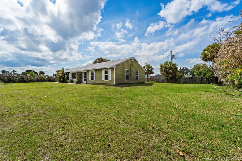 6285 Southeast Highland Avenue Stuart, FL 34997 - Photo 3 of 24 a view of a house with a big yard and large trees