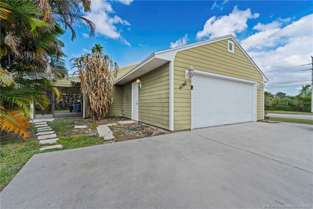 6285 Southeast Highland Avenue Stuart, FL 34997 - Photo 5 of 24 a view of a house with a yard and potted plants