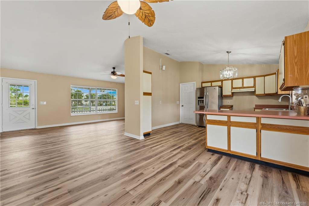 6285 Southeast Highland Avenue Stuart, FL 34997 - Photo 10 of 24 a large kitchen with cabinets wooden floor and a stainless steel appliances