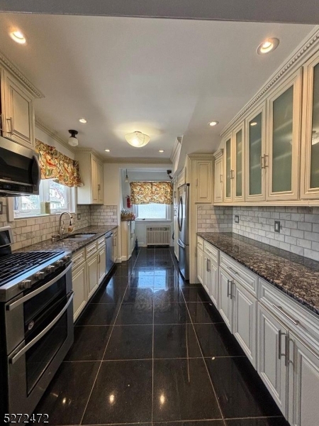 a large kitchen with stainless steel appliances lots of counter space and windows