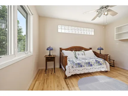 a bedroom with a bed and wooden floor