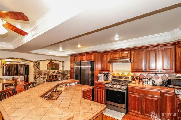 a large kitchen with stainless steel appliances kitchen island granite countertop a sink and cabinets